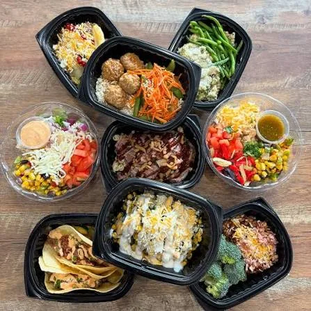 Overhead flat lay of Clean Eatz meals in trays and bowls